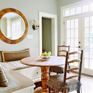 small corner banquette with round table and round mirror