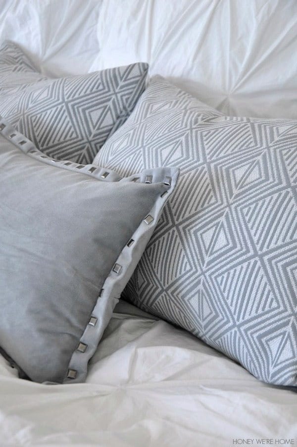 neutral master bedroom, gray and white pillows and bedding
