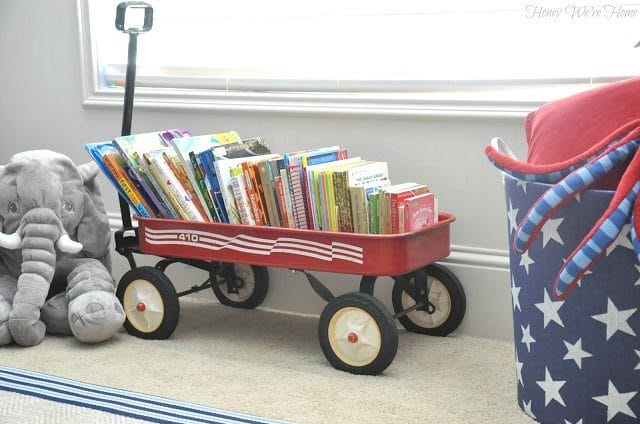 An old red wagon doubles as book storage in a kid's room
