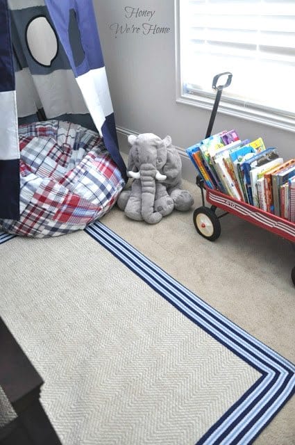 Big boy room with Pottery Barn striped canopy, chenille border rug and wagon to store books