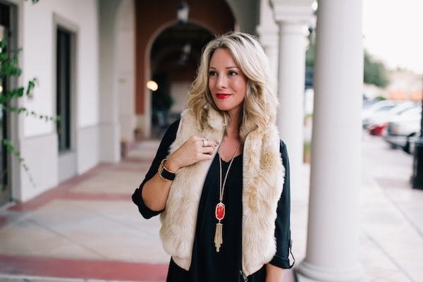 Fall fashion - little black dress with red Kendra Scott necklace and fringe heels + faux fur vest