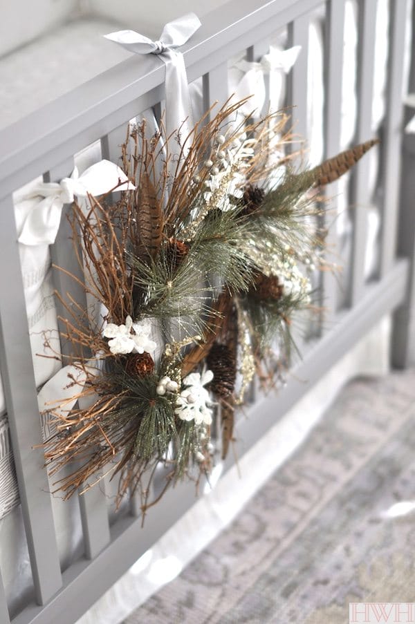Pretty holiday wreath hung from crib in nursery | Honey We're Home
