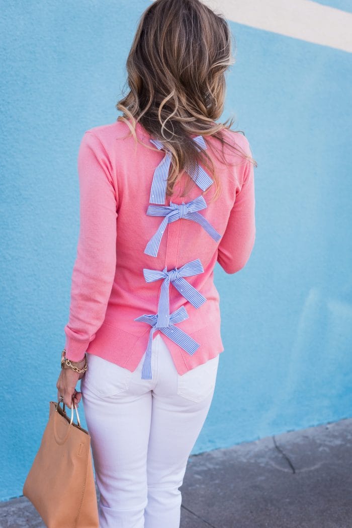 Transitional Spring Outfit- bow back sweater with white jeans, heels and tan bag 