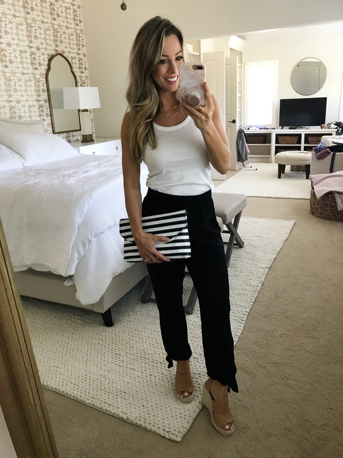Spring Outfit - black ankle tie pants with white tank and striped clutch