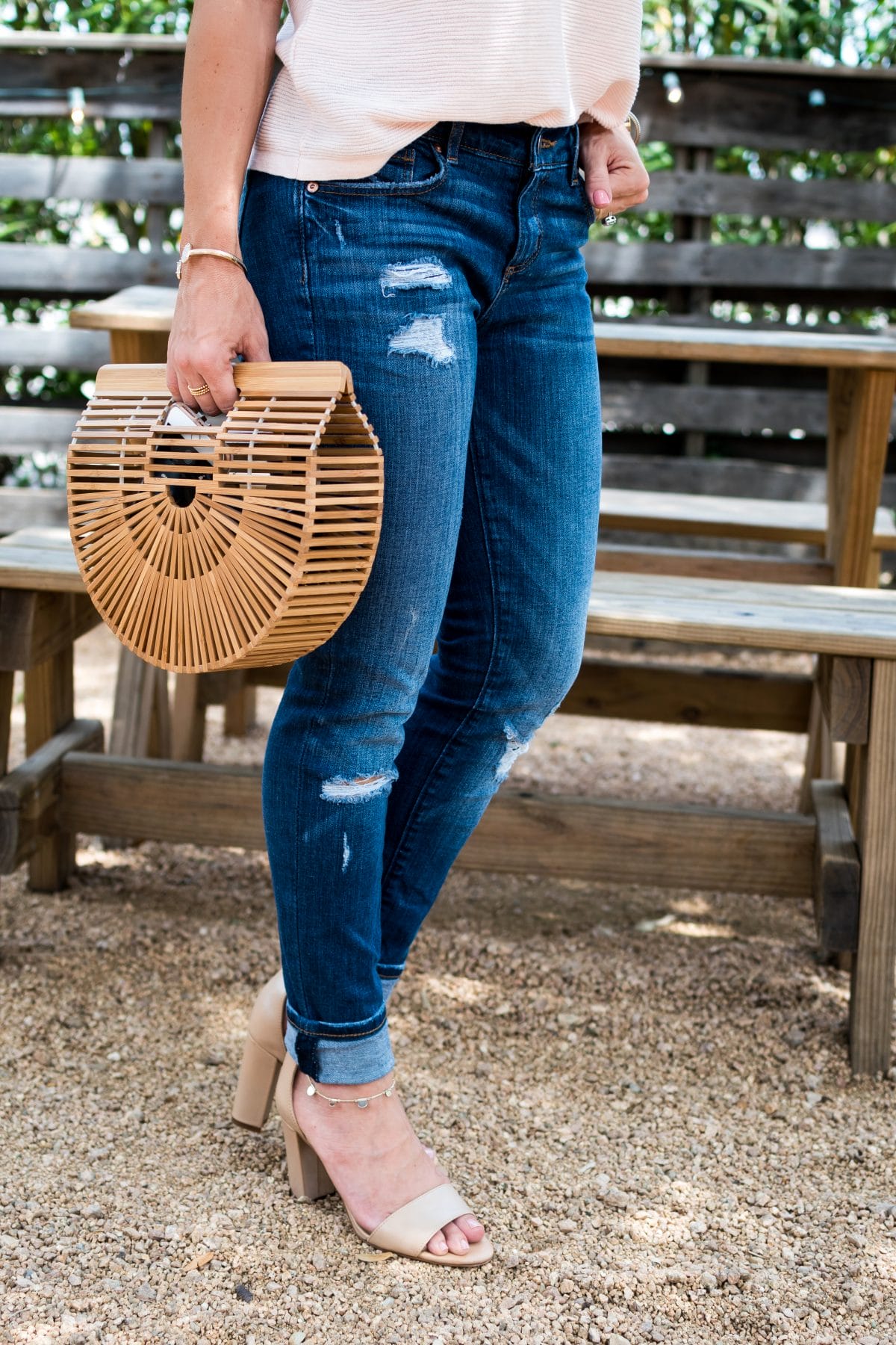 Spring Outfit- pink flutter sleeve top with distressed jeans, wooden bag, and heels 