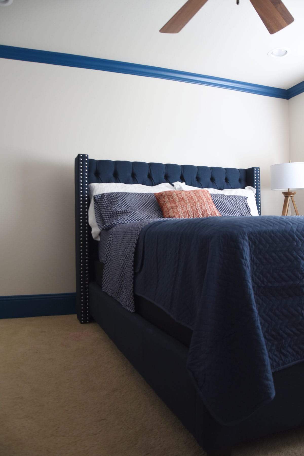 Navy upholstered bed with nailhead trim