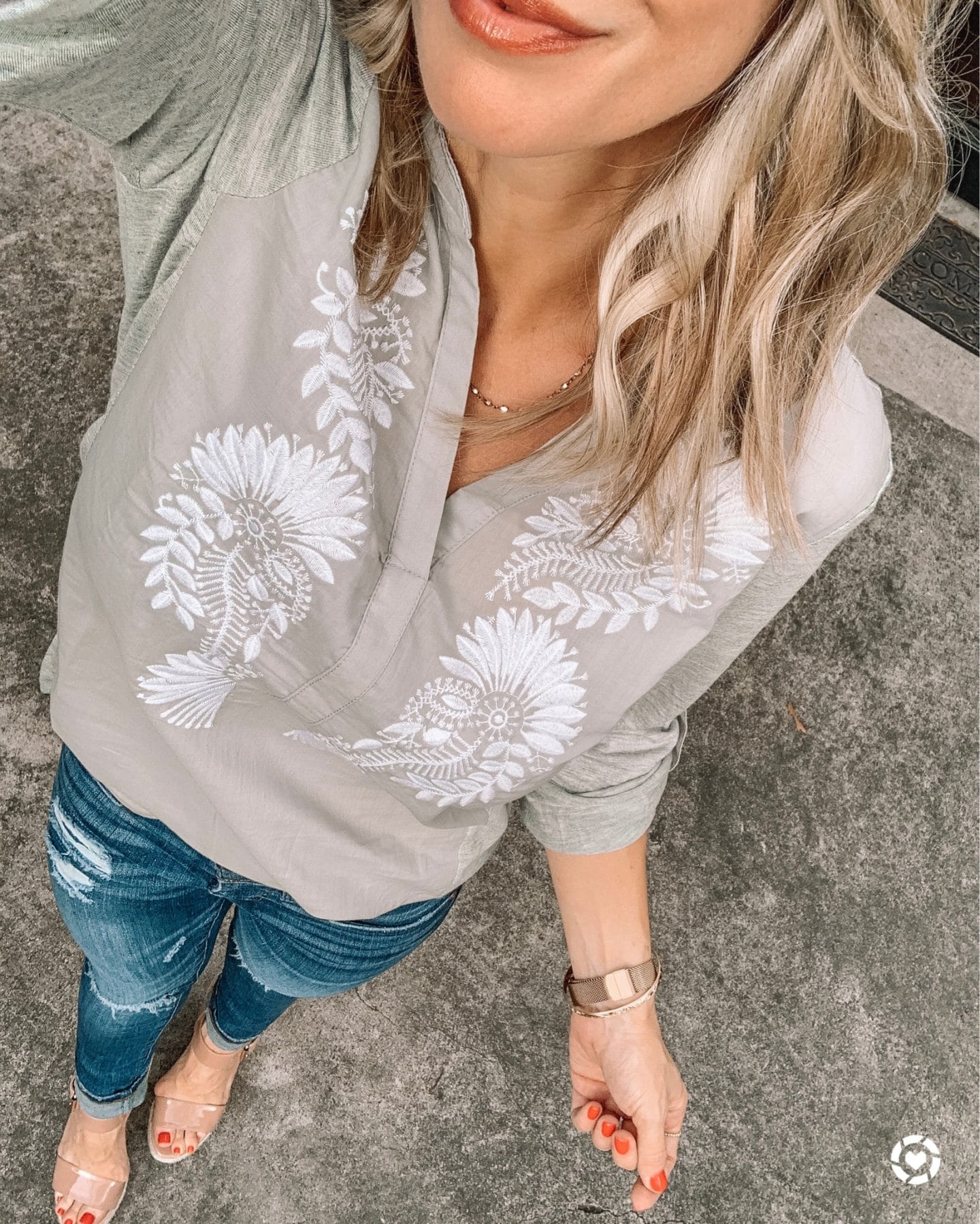 grey and white embroidered top with jeans