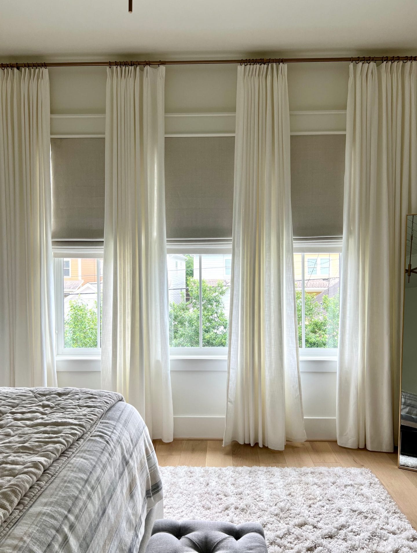 neutral bedroom with white drapes and shades